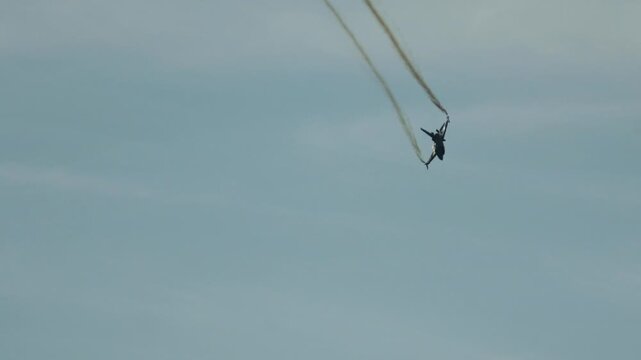 Military F16 Fighting Falcon jet diving with smoke trail