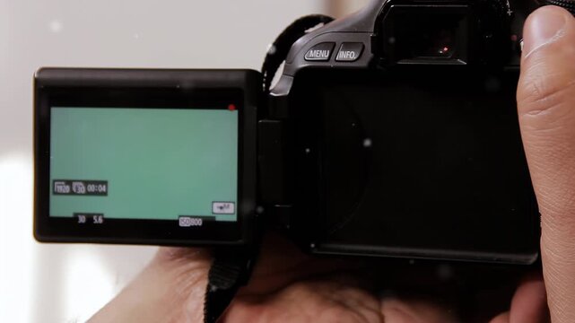 Close Up of Photographer Holding DSLR Camera with Green Screen Articulated Display - 4K