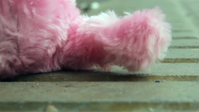 Close Up Of Fluffy Pink Toy Dog Wagging Tail On Pavement Ground - 4K