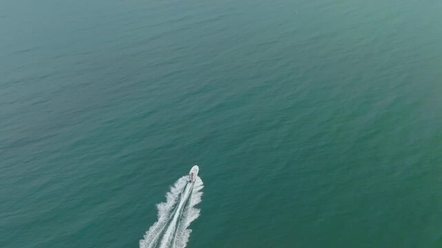 aerial drone view of boat going fast in ocean