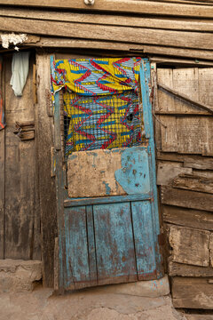 Wooden door with printed fabric curtain, Elmina, Ghana