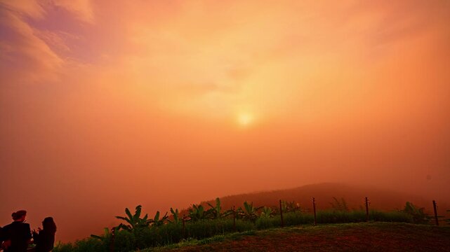 Time lapse Sea of Mist at YunLai viewpoint Baan Santichon. Beautiful sunrise landscape above a sea of mist with dramatic clouds, mountain silhouettes and warm golden sunlight illuminating the horizon
