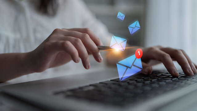 A close-up view of hands typing on a laptop with animated email notifications appearing above, depicting the essence of modern communication in a digital workspace. Gantry