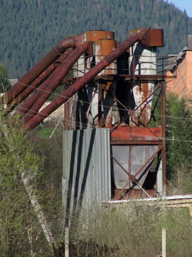 Old industrial cyclone dust collector system at furniture factory outdoor