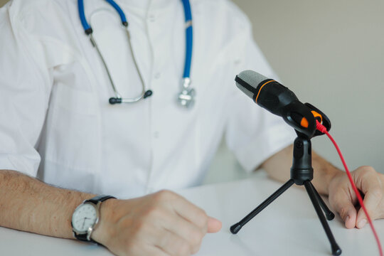 Doctor in a white coat with a stethoscope hosting a medical podcast and giving professional health recommendations into a microphone.