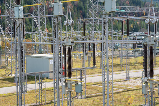 Am Wasserkraftwerk der Firma Uniper an der Isar bei Kr&uuml;n steht ein elektrisches Umspannwerk mit Transformatoren, Isolatoren und Stromleitungen.
