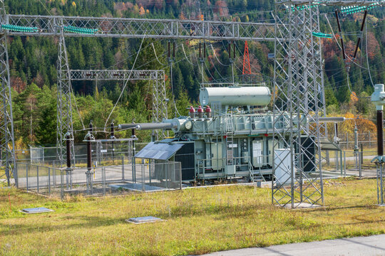 Am Wasserkraftwerk der Firma Uniper an der Isar bei Kr&uuml;n steht ein elektrisches Umspannwerk mit Transformatoren, Isolatoren und Stromleitungen.