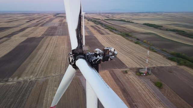 Aerial view of a burnt and damaged wind turbine standing in a vast agricultural field in Vladimirovac, Vojvodina, Serbia.