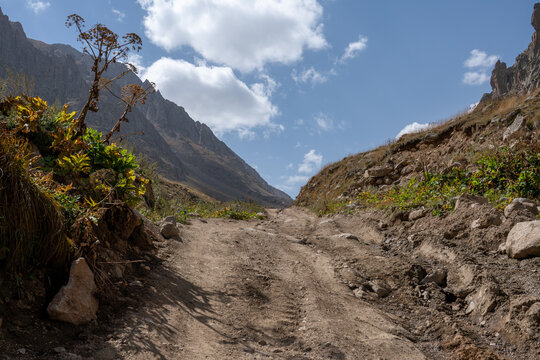 Rocky Mountain Hiking Trail Through a Dramatic Mountain Valley Under a Blue Sky.