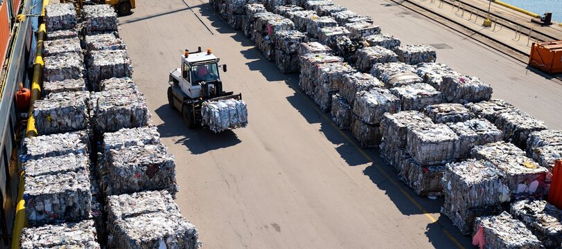 Compacted recycled metal organized in outbound rows at industrial staging yard near river terminal