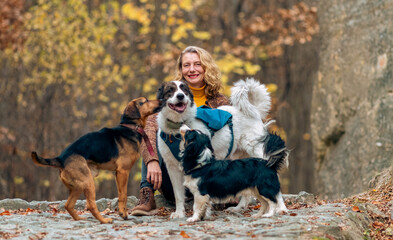 Obraz premium happy woman with dogs playing outdoors in autumn forest