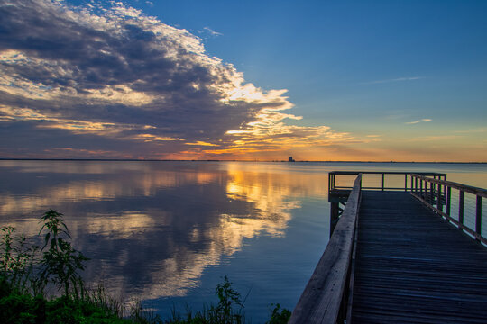 Scenic morning sunrise over the Indian River Lagoon from the Kirk Point Park boardwalk pier in Titusville, Florida.