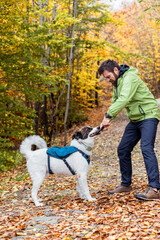 Obraz premium happy white dog with owner in autumn forest