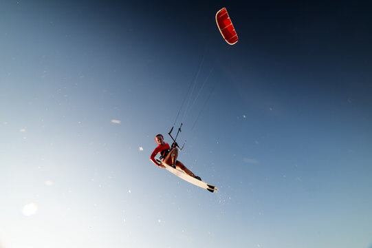 Kitesurfer Jumping High Against Clear Blue Sky