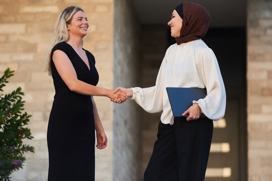 Businesswomen Shaking Hands Outside Office Building, Diverse Professionals Meeting With Laptop