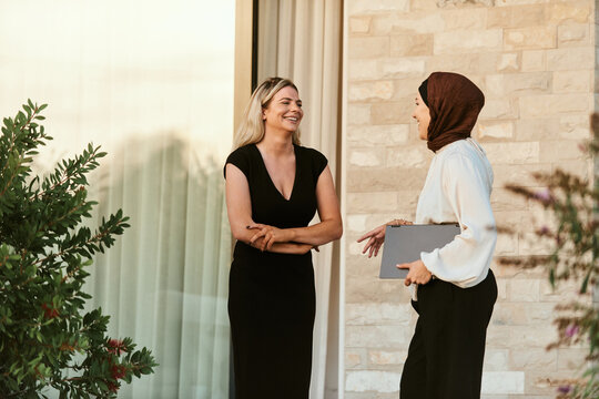 Professional Business Conversation Between Multicultural Female Colleagues Outside Modern Office Building