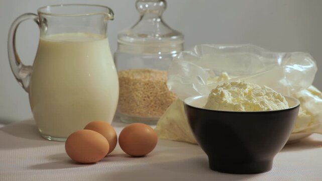 Dairy products still life. Milk jug, butter, cottage cheese and brown eggs table