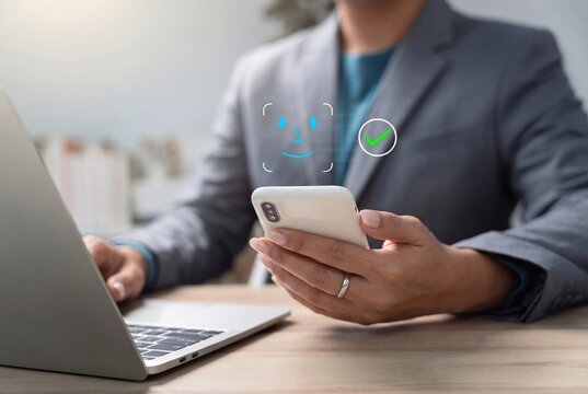 Biometric facial recognition on smartphone, professional using face ID scanning for secure mobile access, digital identity tech.