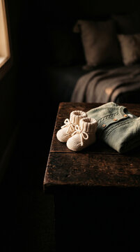 Baby booties and folded outfit in modern commercial stock setting