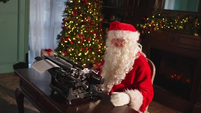 Merry Christmas. Santa mail. Happy Santa typing tact on typewriter for New Year Christmas in festive living room. Santa typing letter on Christmas eve. Mail of Santa Claus. Winter Holiday Celebrations