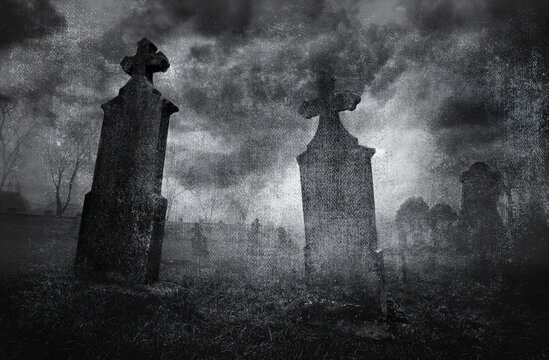 Old creepy graveyard on stormy winter day in black and white