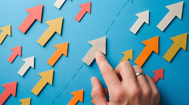Hand moving up an arrow amidst many arrows on blue surface.