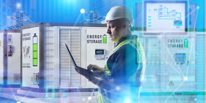 Energy storage facility, engineer uses a laptop to monitor battery containers, control electricity distribution and manage power supply to the electrical grid.