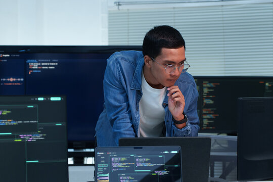 Programmer Analyzing Code on Multiple Screens