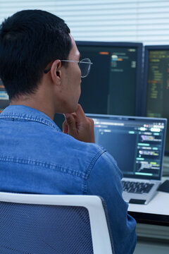 Programmer Analyzing Code on Multiple Screens
