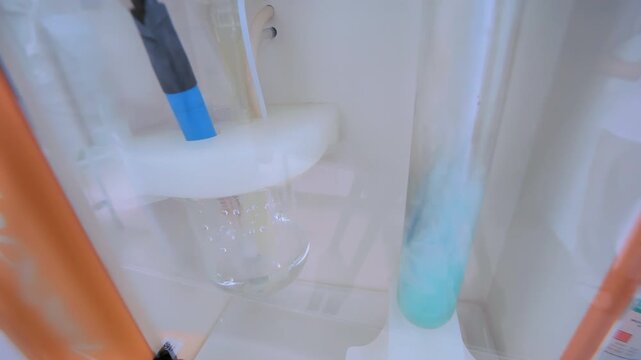 Chemical reaction test tube laboratory. Liquid changing color dark fume hood.