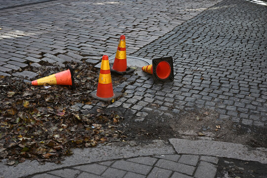 Several orange and yellow traffic cones, including fallen cones