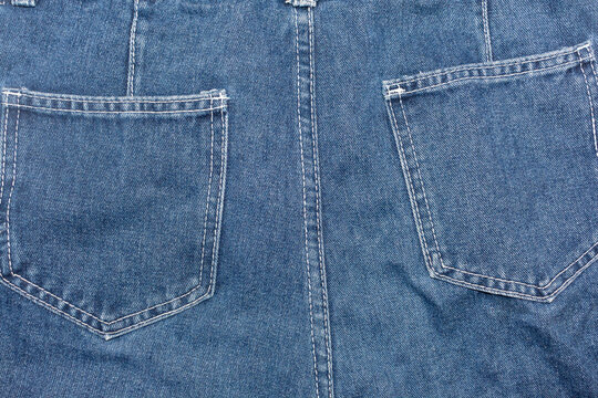 Close-up blue denim jeans back pockets with seam stitching detail
