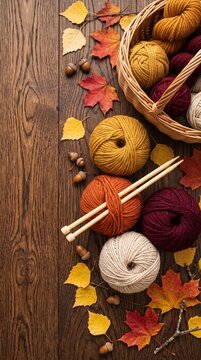 autumn knitting scene with colorful yarn balls, wooden needles, fall leaves and acorns on rustic wooden table