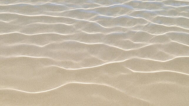 Close-up of a sandy surface with wavy lines. the lines are evenly spaced and run diagonally across the surface, creating a sense of depth and dimension.