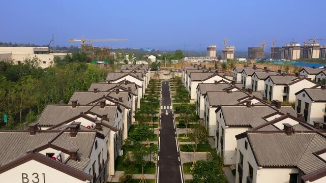 Aerial View of Modern Residential Housing Complex with Construction Cranes in Background