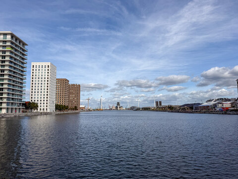 Modern residential towers along the harbor waterfront in Antwerpen, Belgi&euml; with wind turbines in the distance