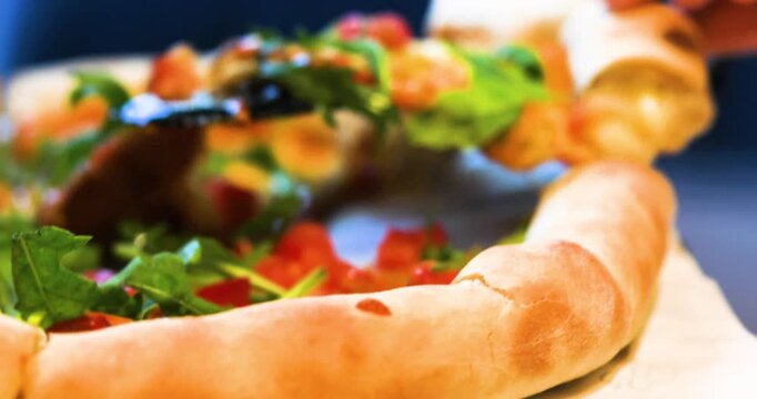 picking up a slice of Margherita pizza with a spatula and placing it on a plate in a pizzeria.