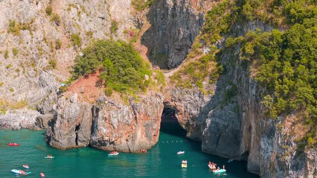 Arco Magno San Nicola Arcella Calabria Italy 70mm Aerial Drone View Natural Arch Cave Sea Kayaks Watercraft Riviera dei Cedri Travel Video 4K UHD