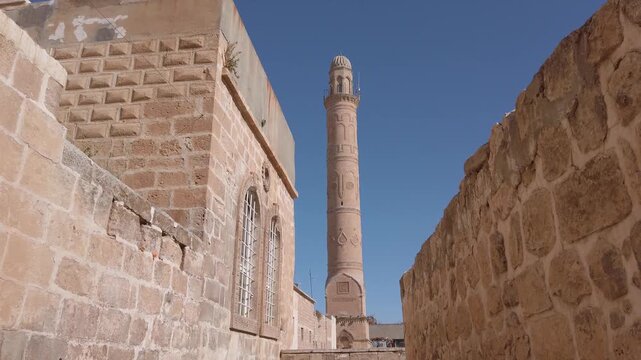 Ulu Cami minaret, Great Mosque of Mardin, Turkey, seen from a narrow alley between the old stone walls of the historic town