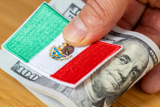 Financial remittances and labor migration concept with Mexican flag patch on a roll of US Dollar banknotes. Cross-border money transfers and North American economy.