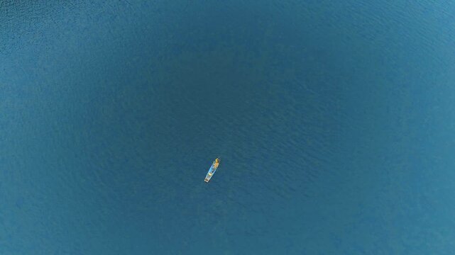 Aerial Top-Down View of a Small Boat on a Vast Blue River