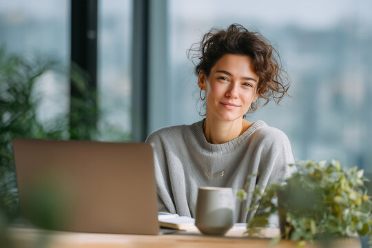 Confident Young Woman Entrepreneur Working Remotely on Laptop at Minimalist Desk