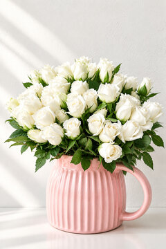 Roses blanches dans une cruche rose isol&eacute;