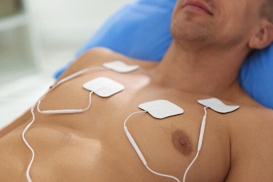 Patient with ECG electrodes attached to his chest in clinic, closeup