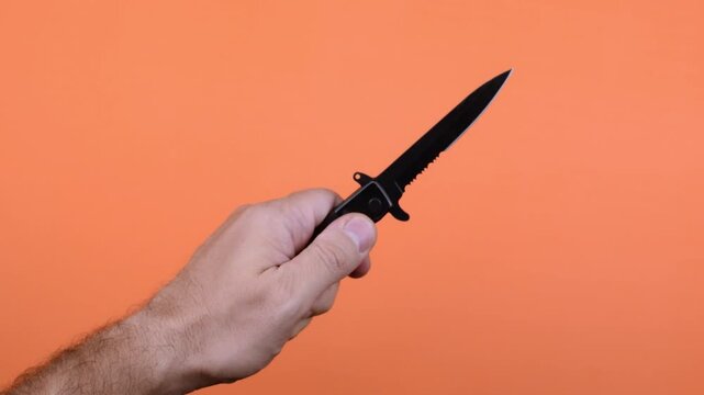 La mano de un hombre abre una navaja y la empu&ntilde;a