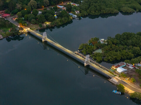 Suspension bridge connecting town over river at night