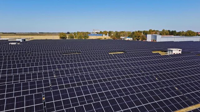 Aerial view of a large solar farm with rows of photovoltaic panels under a clear blue sky in Temerin, Vojvodina, Serbia.