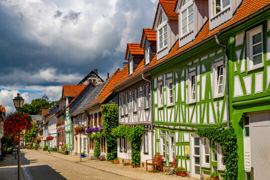 Picturesque half-timbered houses along a cobbled street in Idstein, Hesse, Germany, with colorful facades, flowers and traditional architecture under a dramatic summer sky.