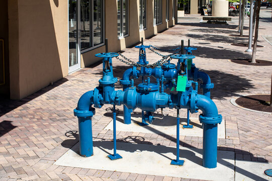 Drinkable water backflow pipes prevention device with gate valves and security chain locks installed in an urban neighborhood