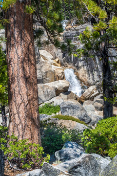 Bassi Falls, Eldorado National Forest. Tall trees frame the scene in a natural setting.